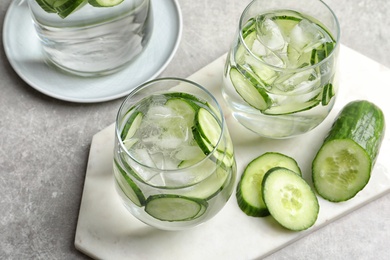 Photo of Glasses with fresh cucumber water served on table