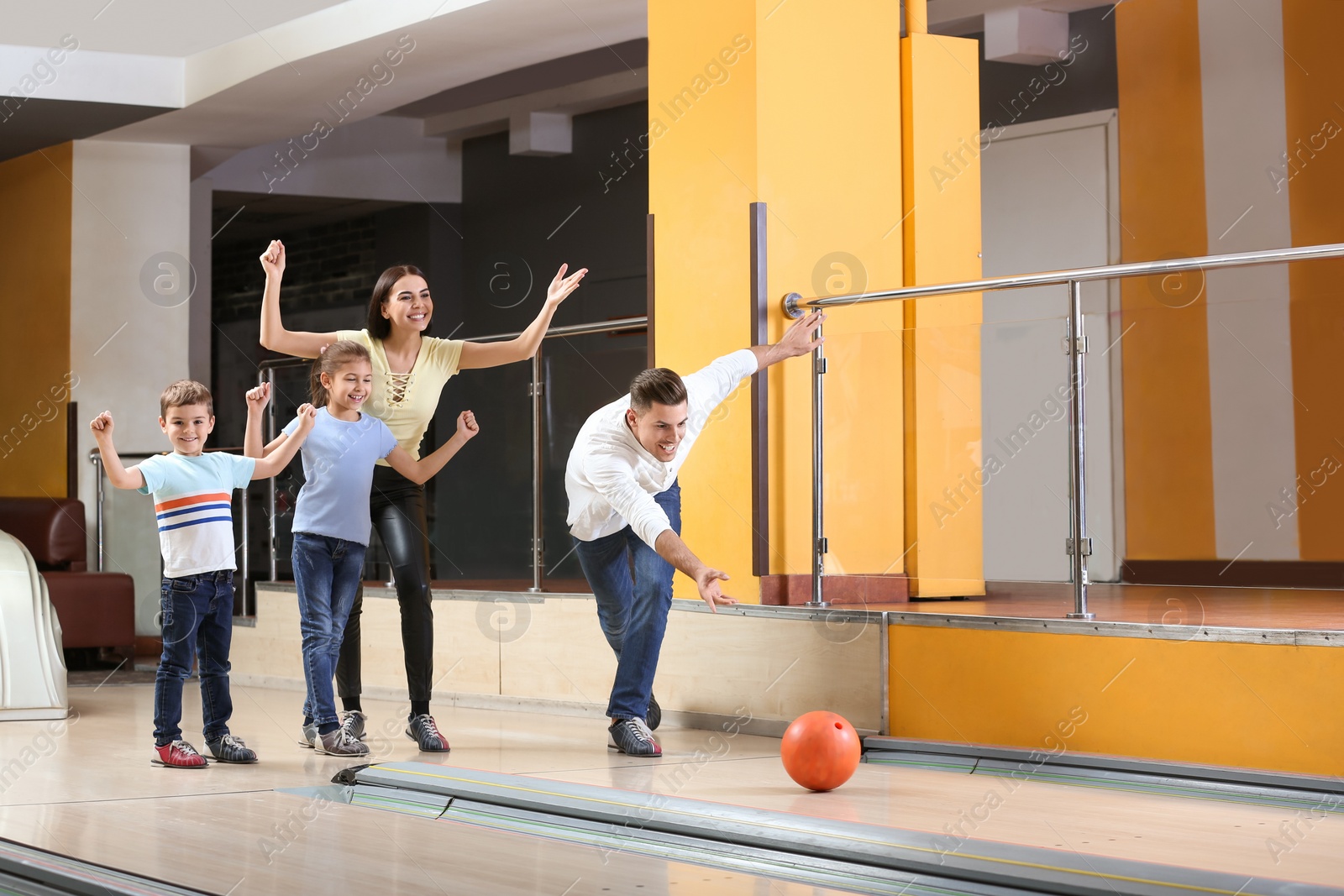 Photo of Happy family spending time together in bowling club