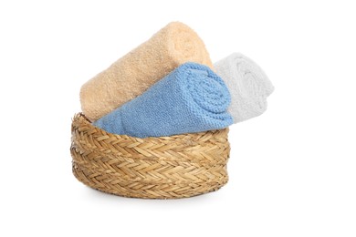 Photo of Wicker basket with rolled bath towels isolated on white
