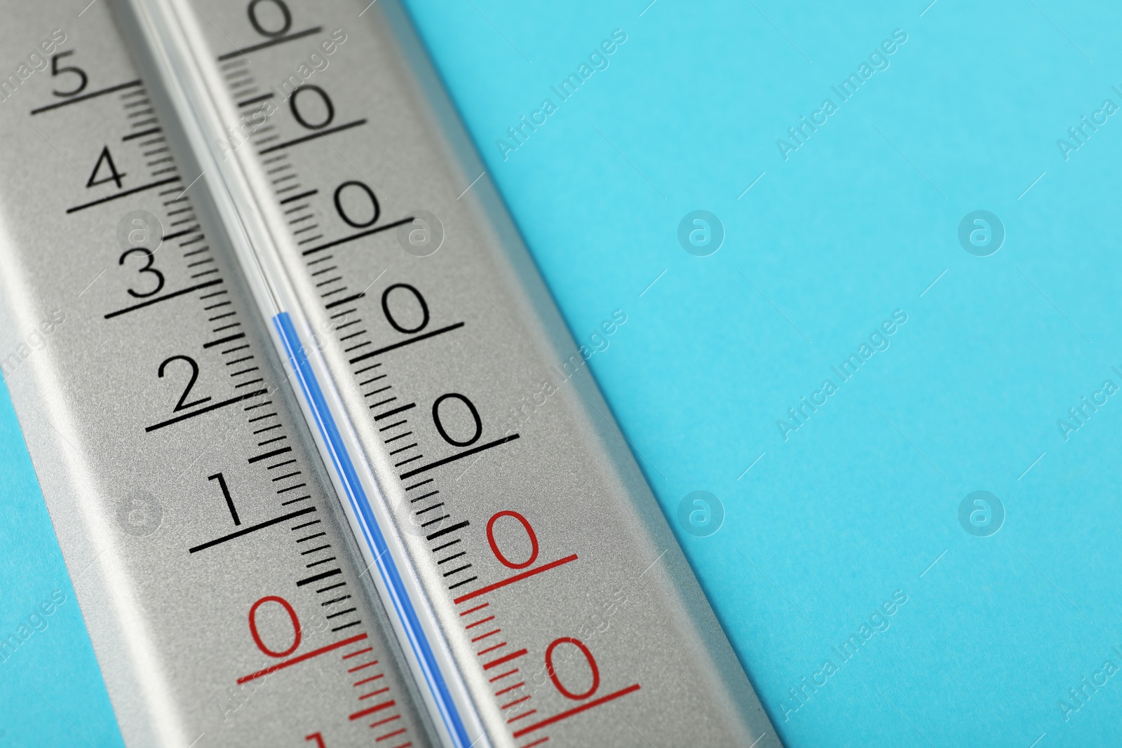 Photo of Weather thermometer on light blue background, closeup. Space for text