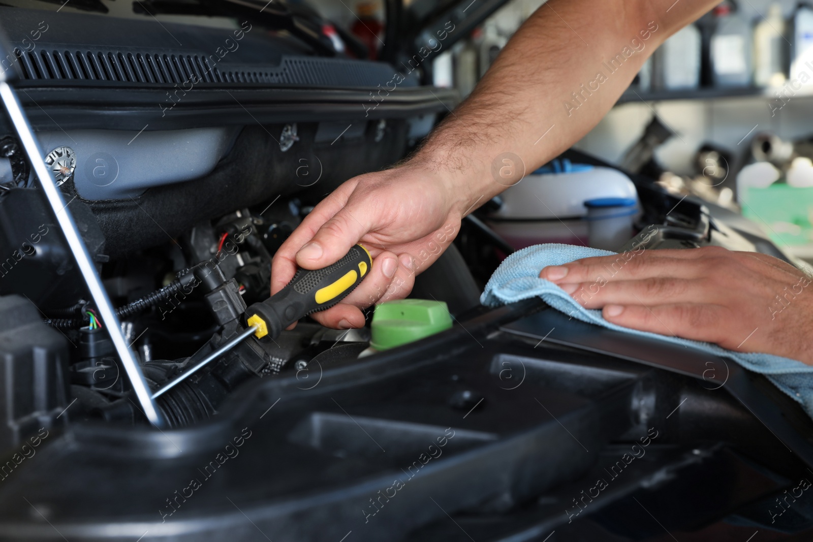 Photo of Professional auto mechanic fixing modern car in service center, closeup