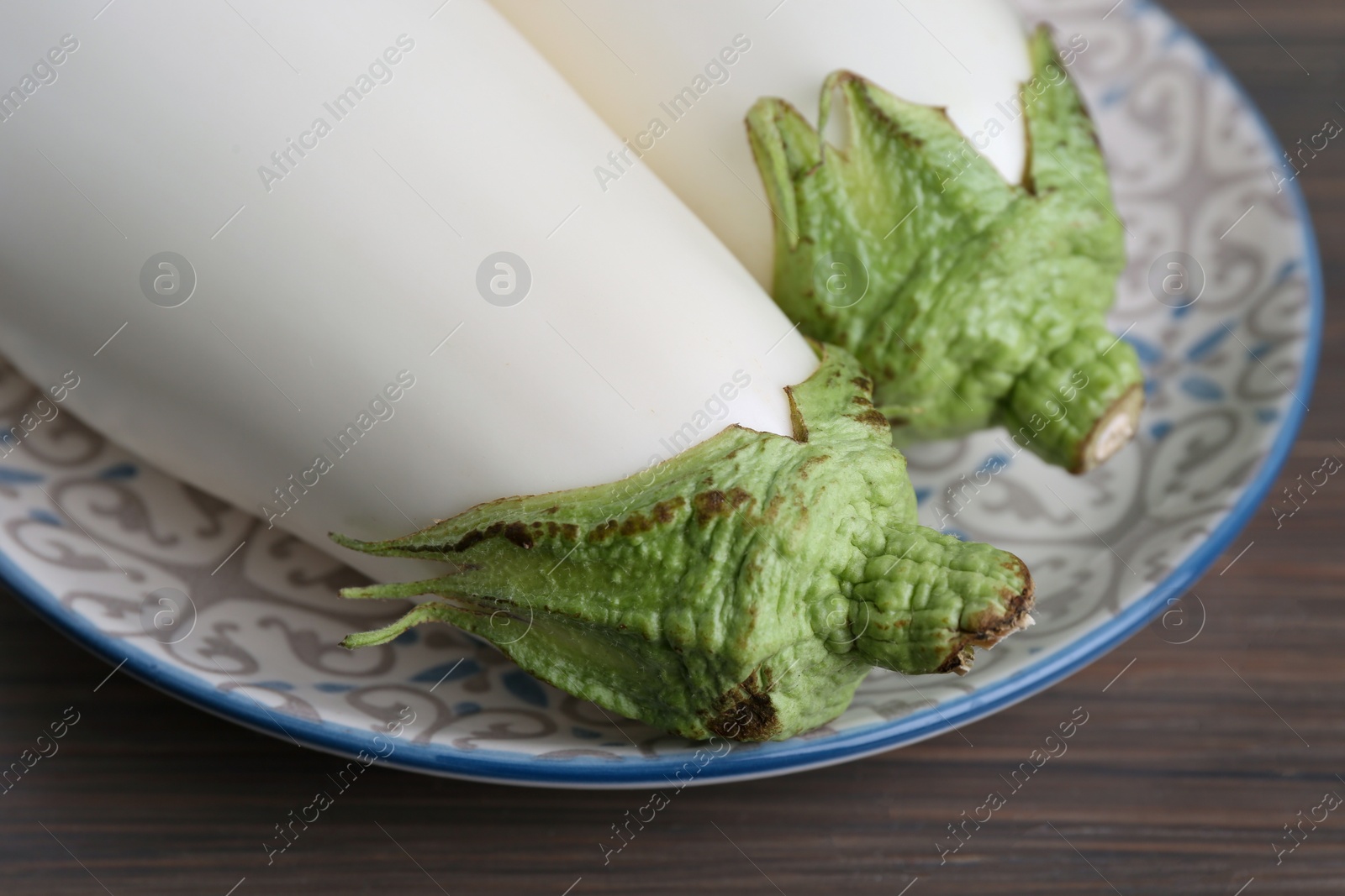 Photo of Two fresh white eggplants on wooden table, closeup