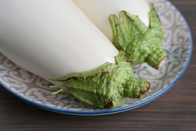 Two fresh white eggplants on wooden table, closeup