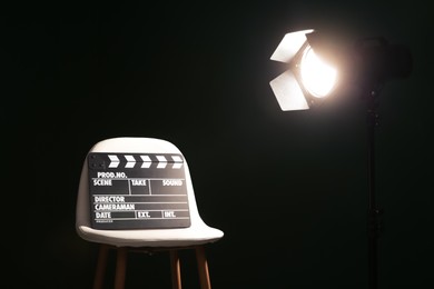 Photo of Chair with clapperboard under spotlight in studio