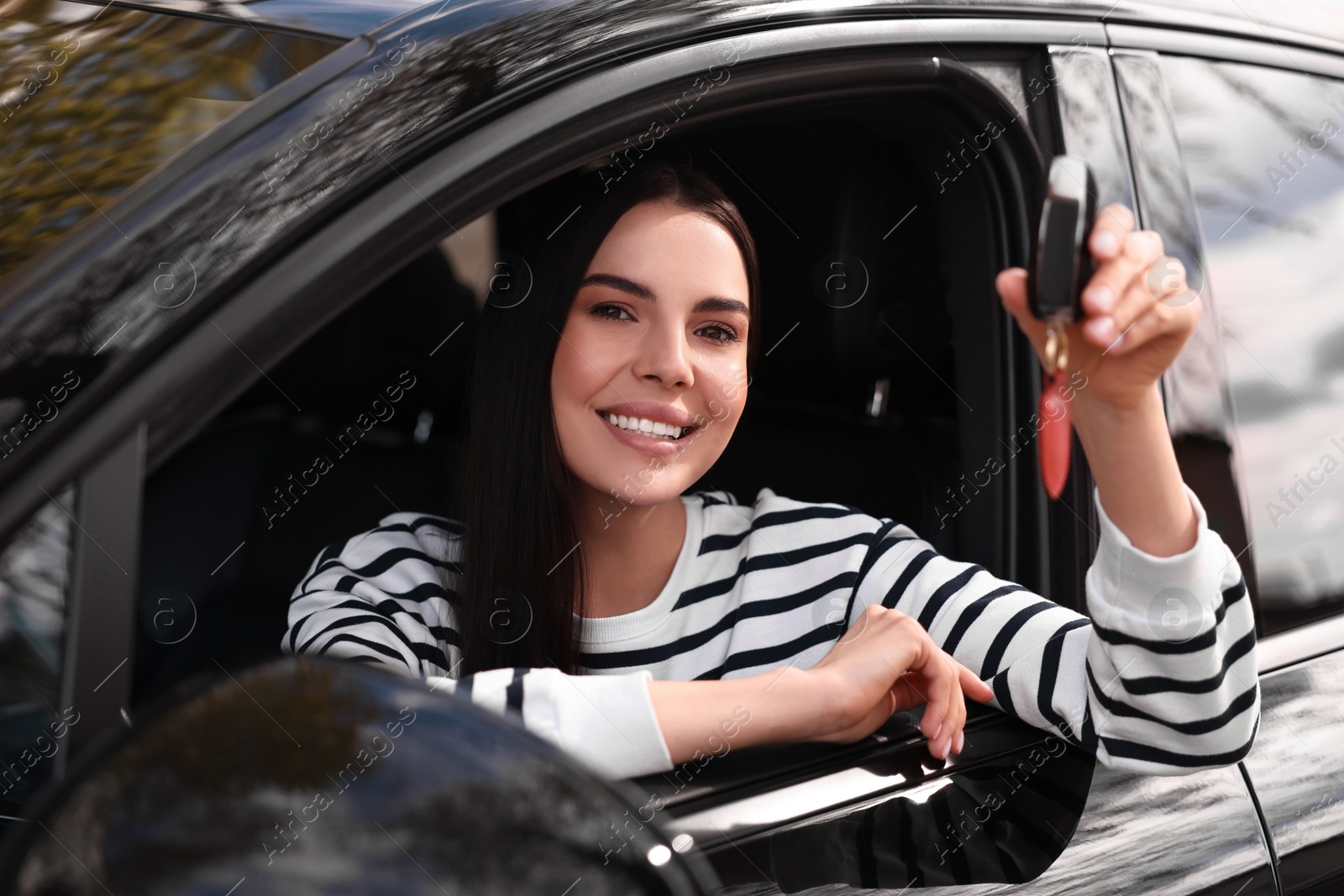 Photo of Woman holding car flip key inside her vehicle