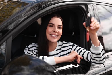 Photo of Woman holding car flip key inside her vehicle