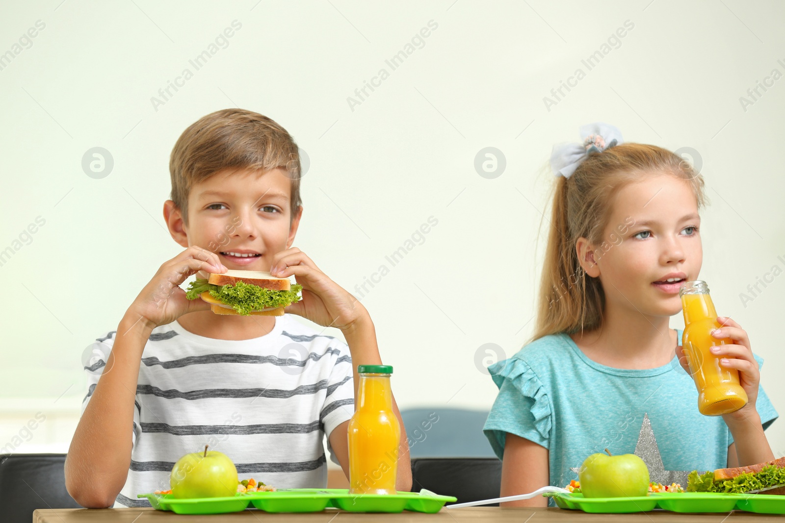 Photo of Happy children eating healthy food for lunch in school canteen