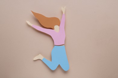 Woman`s health. Paper female figure on beige background, top view