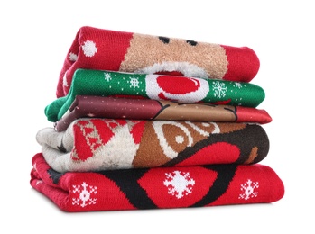 Stack of warm Christmas sweaters isolated on white