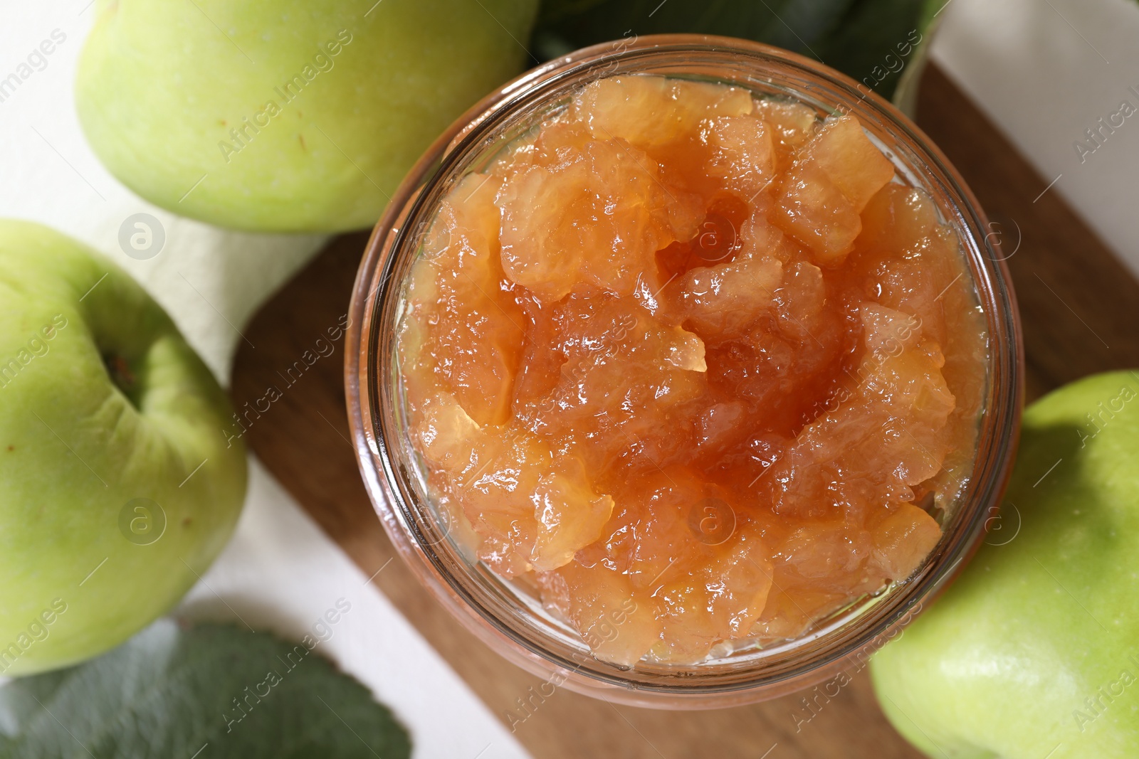 Photo of Glass jar of delicious apple jam and fresh fruits on white table, flat lay