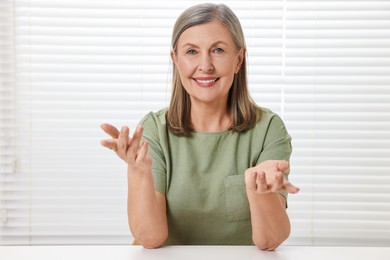 Happy woman at white table in room