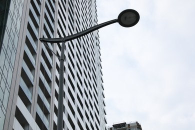 Photo of Georgia, Batumi - July 07, 2022: Streetlight near modern multistory building under cloudy sky