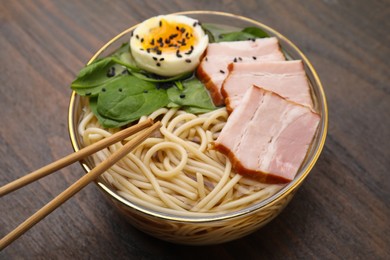 Photo of Delicious ramen with meat on wooden table, closeup. Noodle soup