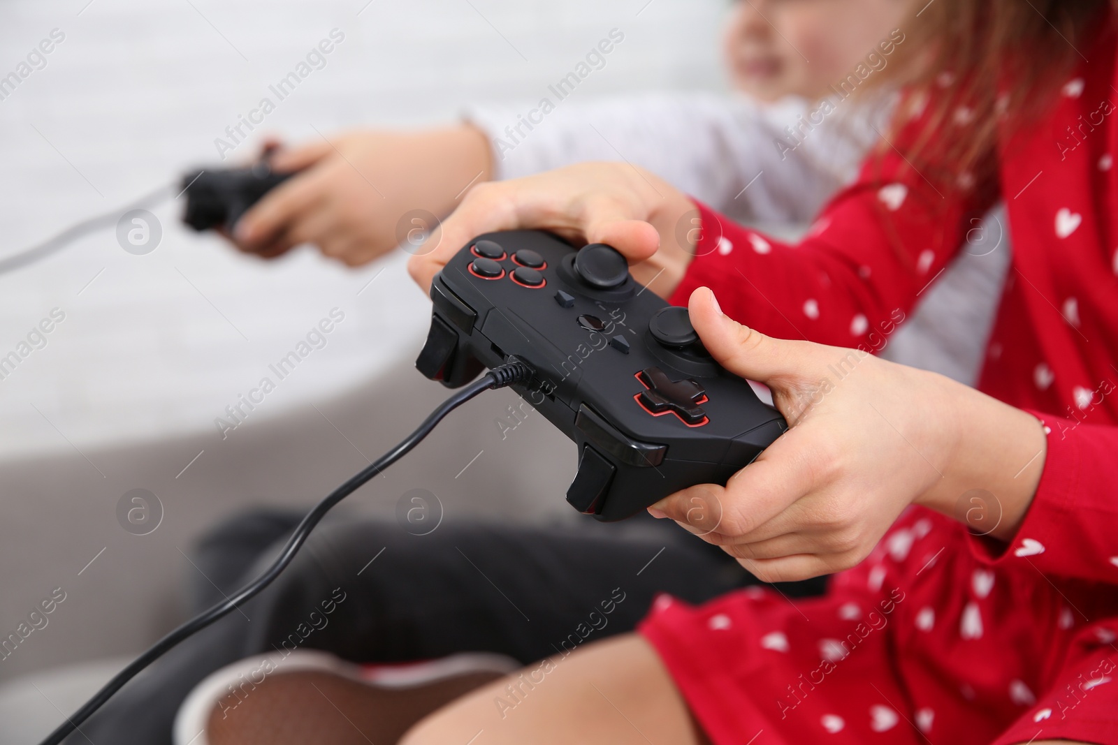 Photo of Children playing video game at home, closeup