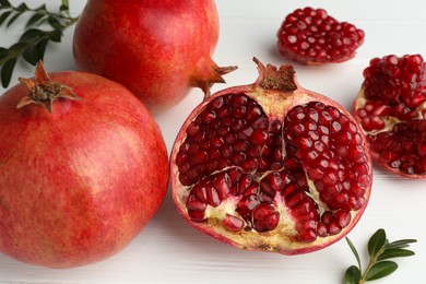 Fresh pomegranates on white wooden table, closeup
