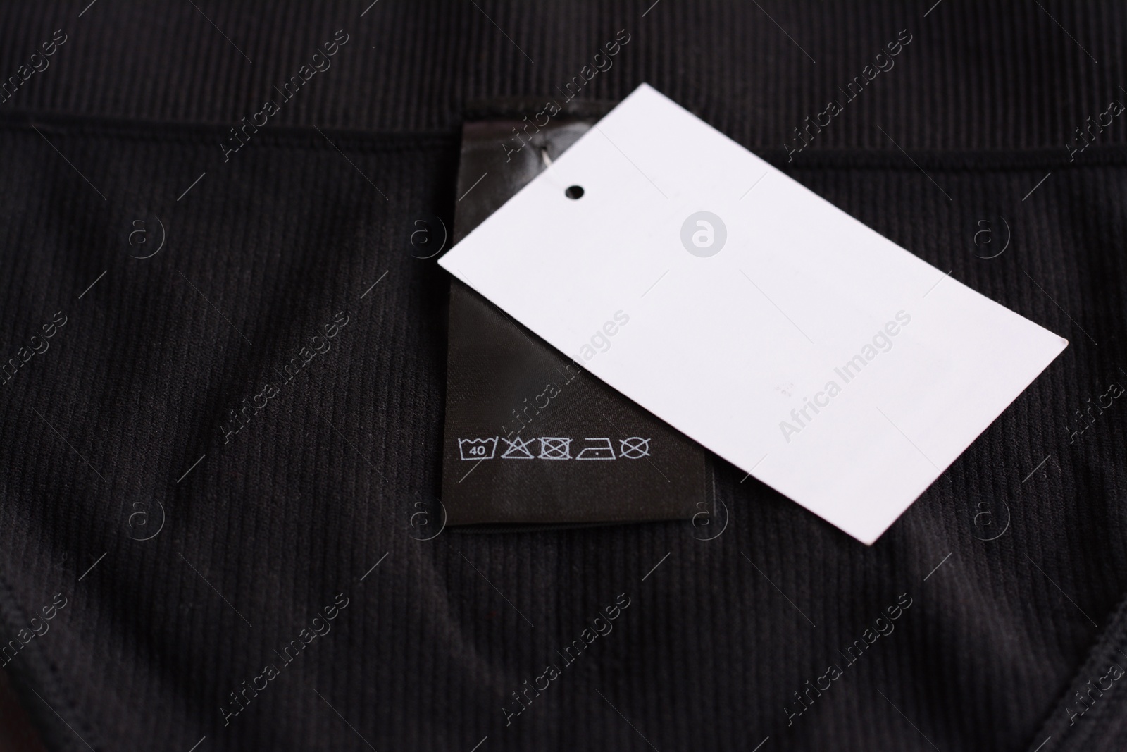 Photo of Clothing label with care information and tag on black garment