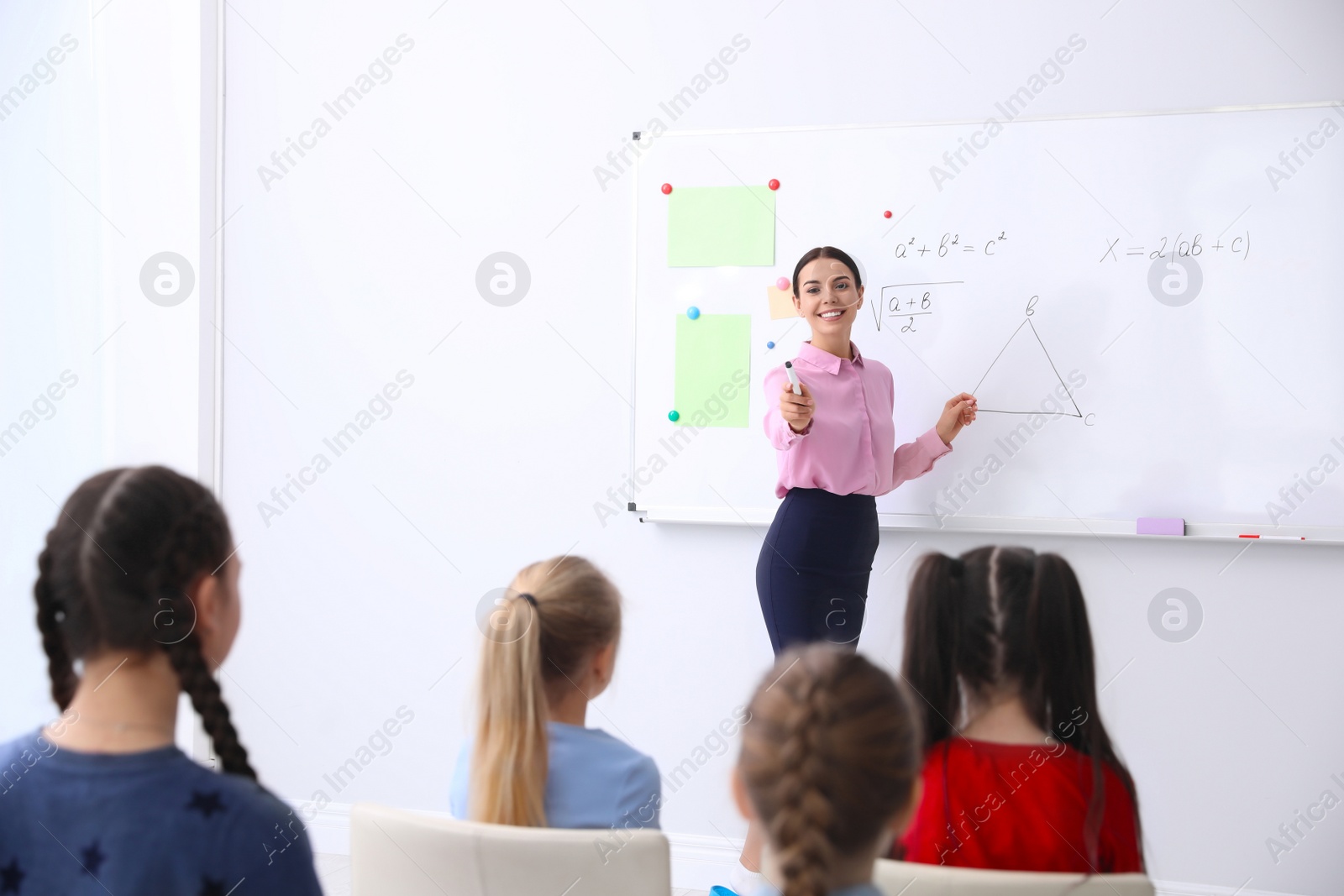 Photo of Young teacher and students in modern classroom