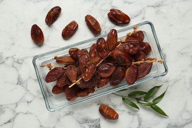 Photo of Tasty sweet dried dates on white marble table, flat lay