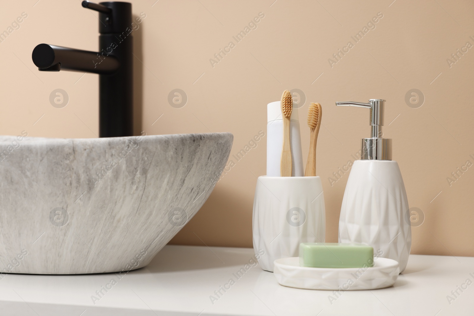 Photo of Different bath accessories and personal care products near sink on bathroom vanity