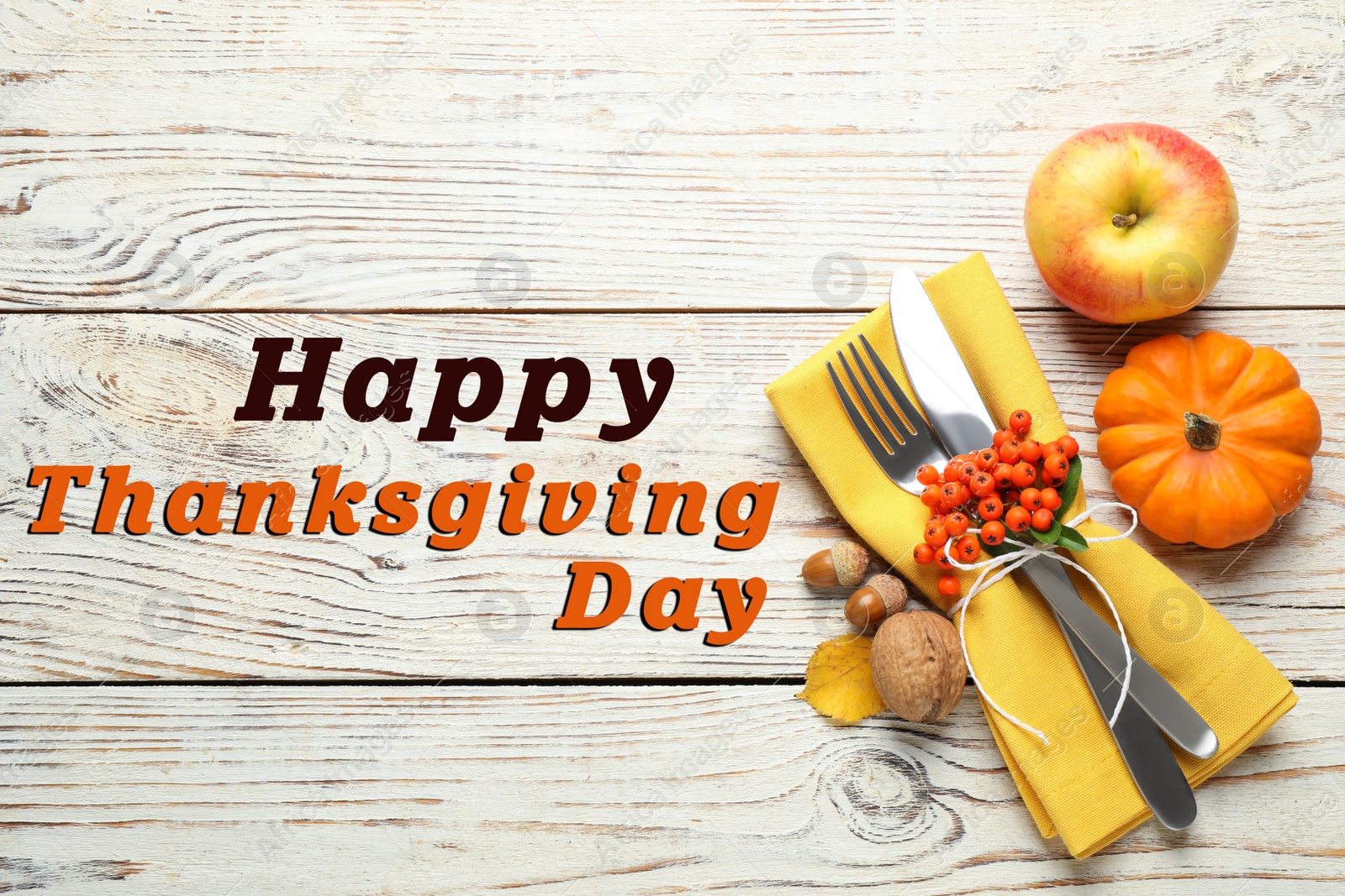 Image of Happy Thanksgiving Day card. Top view of cutlery with napkin and autumn decor on white wooden table