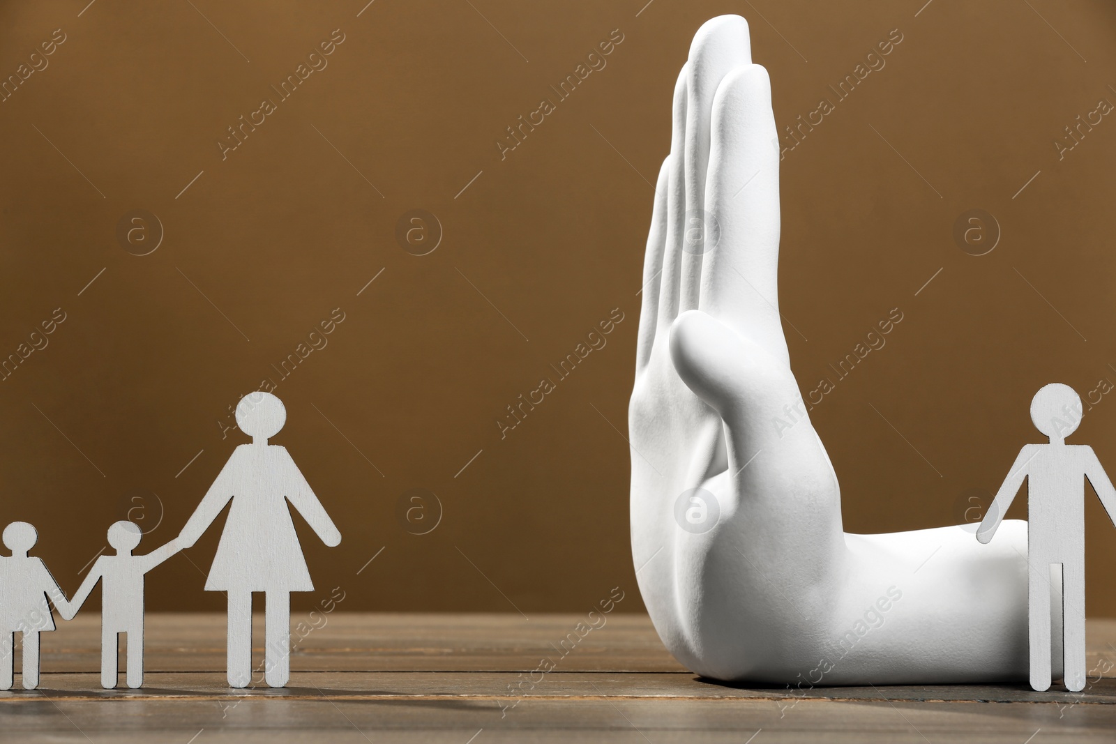 Photo of Divorce concept. Hand model dividing paper figures of woman with children and man on wooden table