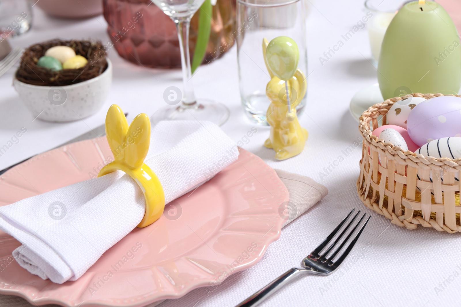 Photo of Festive table setting with napkin ring in shape of bunny ears, closeup. Easter celebration