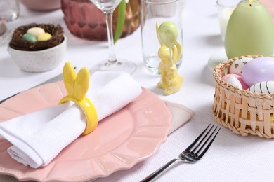 Festive table setting with napkin ring in shape of bunny ears, closeup. Easter celebration