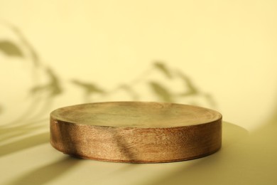 Presentation of product. Wooden podium on yellow background. Space for text