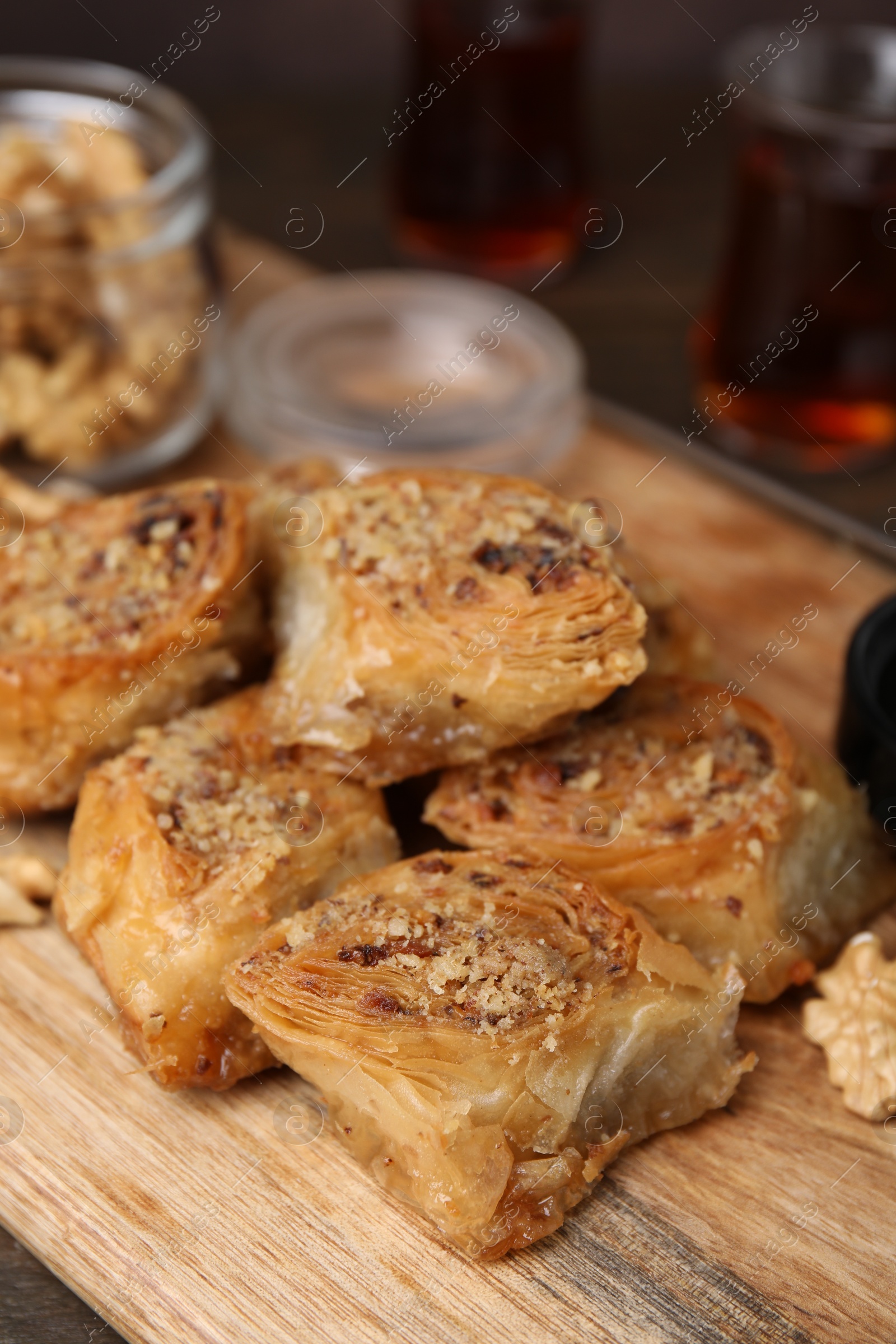 Photo of Eastern sweets. Pieces of tasty baklava on wooden table, closeup