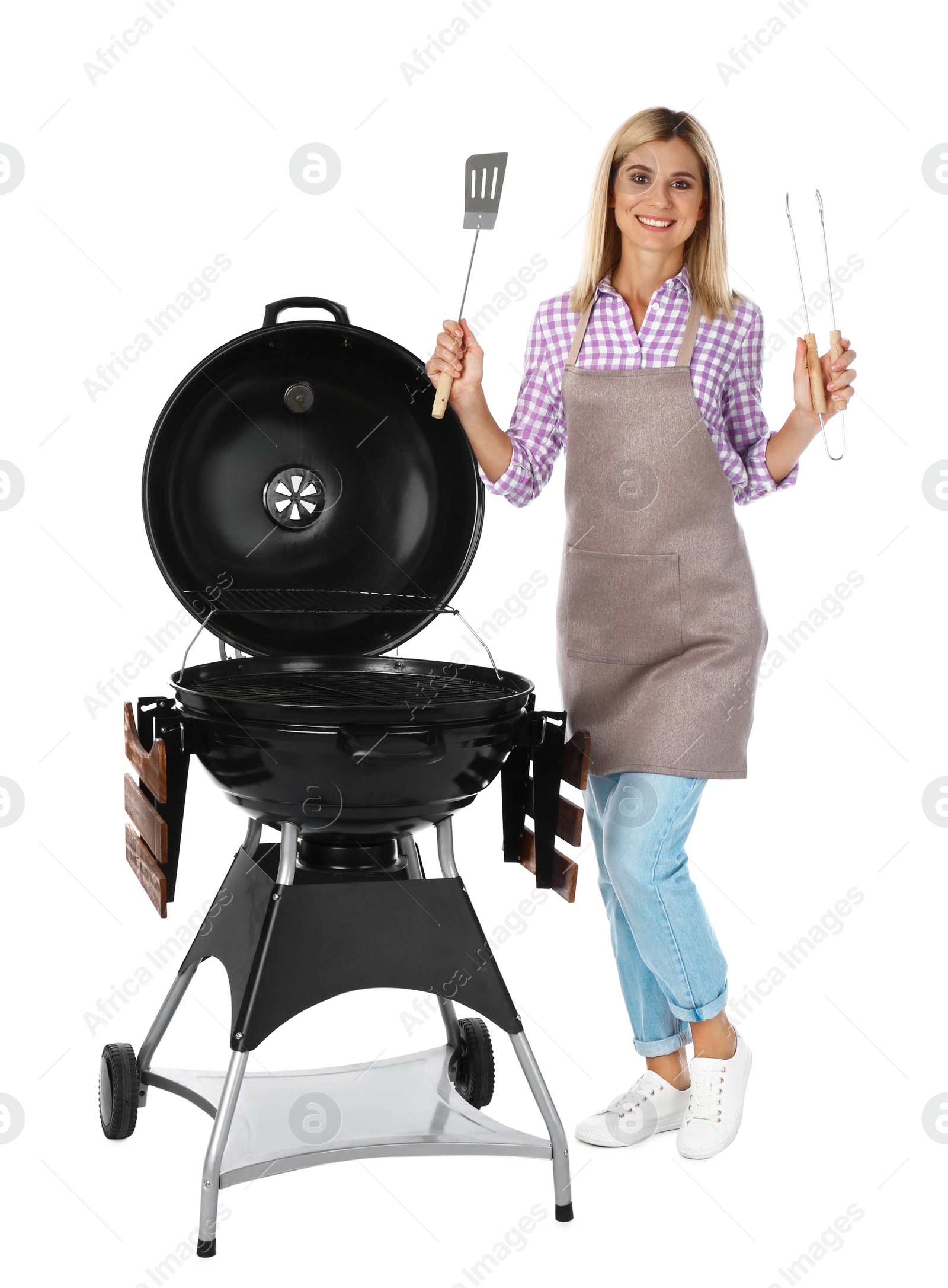 Photo of Woman in apron with barbecue grill and utensils on white background