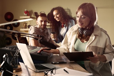 Photo of People working in modern radio studio with professional equipment