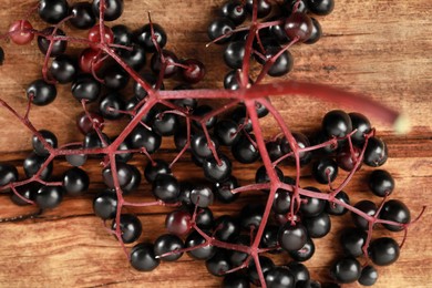 Photo of Black elderberries (Sambucus) on wooden table, top view