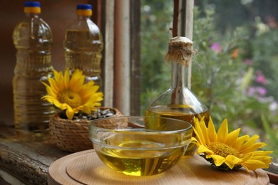 Photo of Organic sunflower oil and flower on window sill indoors, space for text