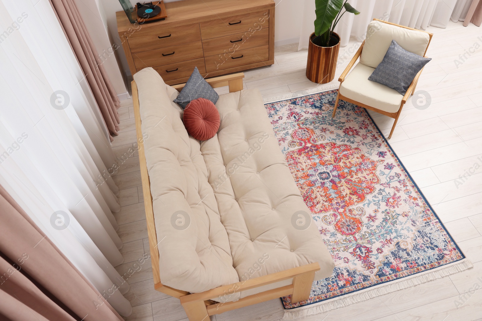 Photo of Beautiful rug, sofa, armchair and chest of drawers indoors, above view