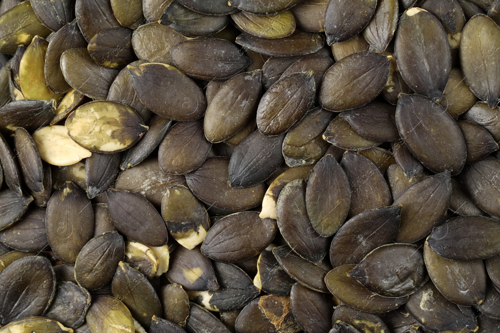 Many peeled pumpkin seeds as background, top view Photo of Many peeled pumpkin seeds as background, top view