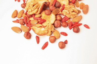 Photo of Pile of mixed dried fruits and nuts on white background, above view. Space for text