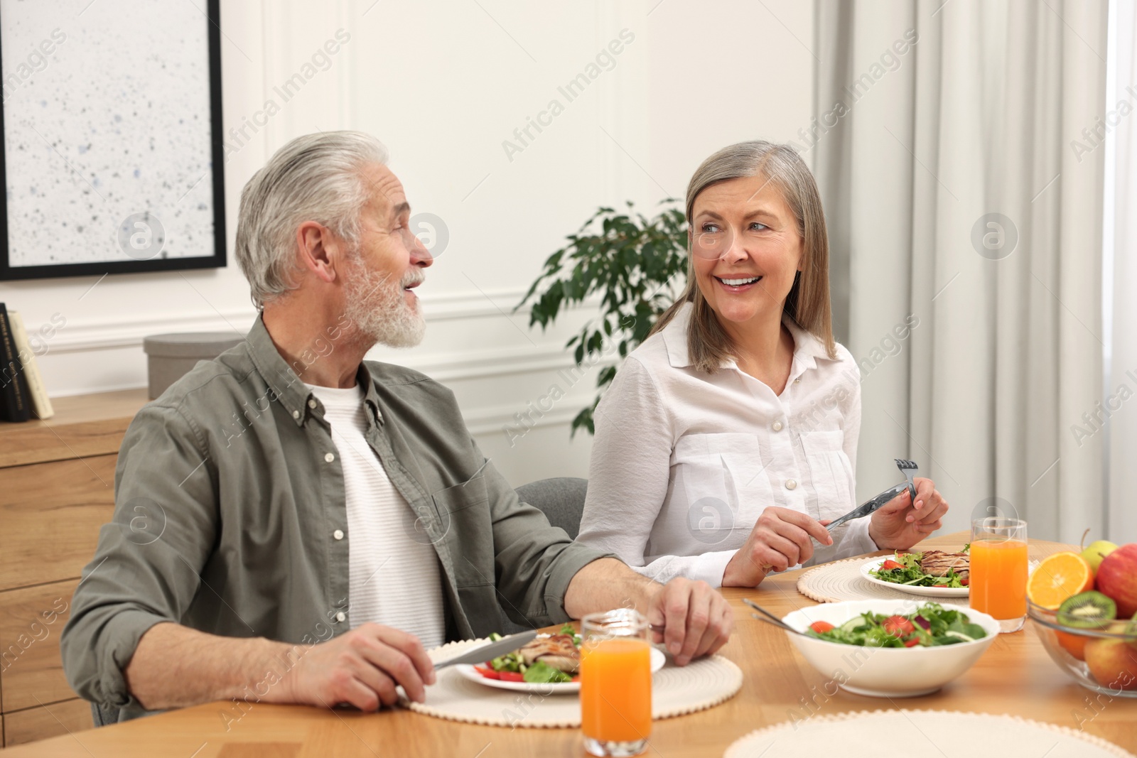 Photo of Happy senior couple having dinner at home