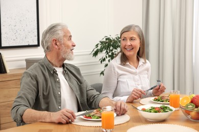 Happy senior couple having dinner at home