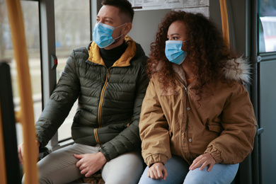 Couple with disposable masks on bus. Virus protection