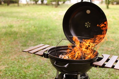 Photo of Modern barbecue grill with fire flames outdoors