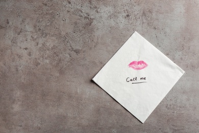 Photo of Paper napkin with lipstick mark, words CALL ME and space for text on grey background, top view