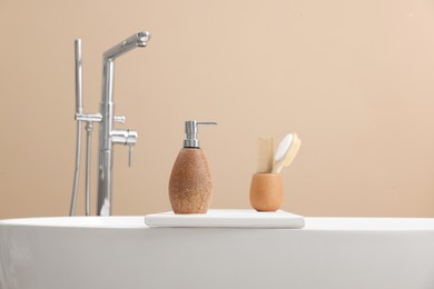 Different personal care products and accessories on bath tub in bathroom