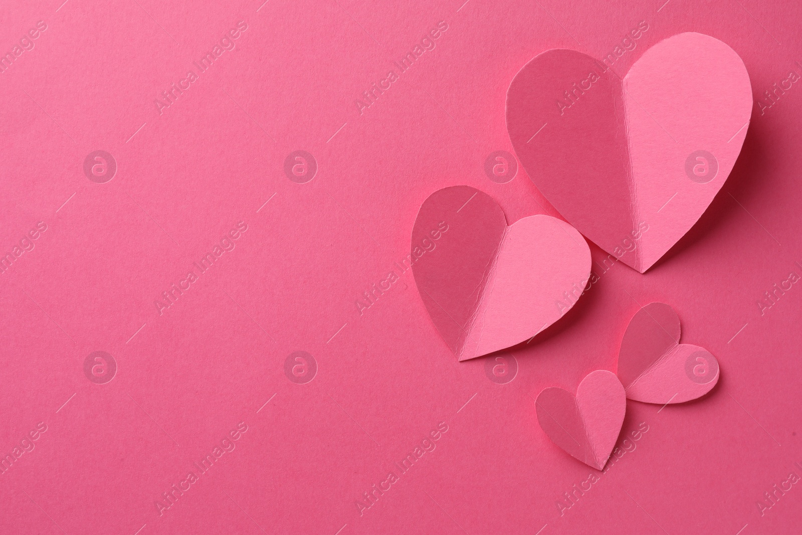 Photo of Paper hearts on pink background, flat lay. Space for text