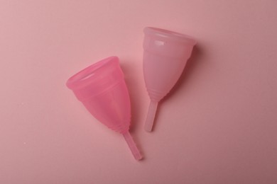 Menstrual cups on pink background, top view