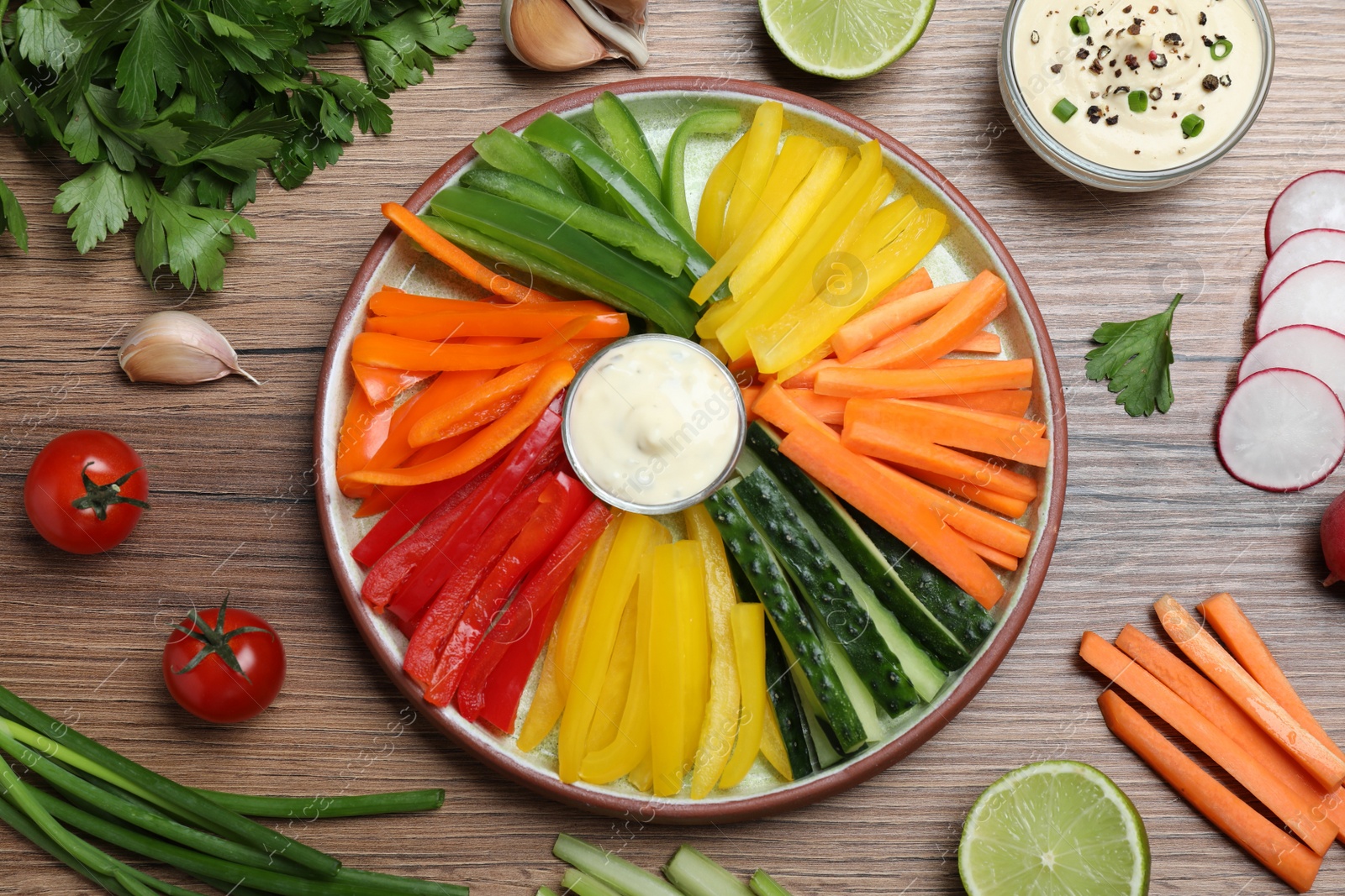 Photo of Fresh raw vegetable sticks and sauce on wooden table, flat lay