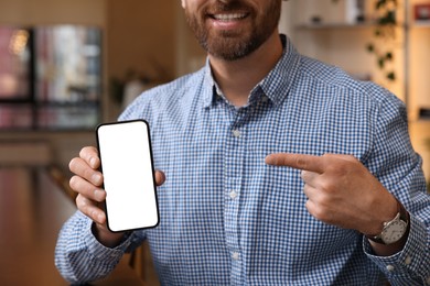 Man showing his smartphone in cafe, closeup