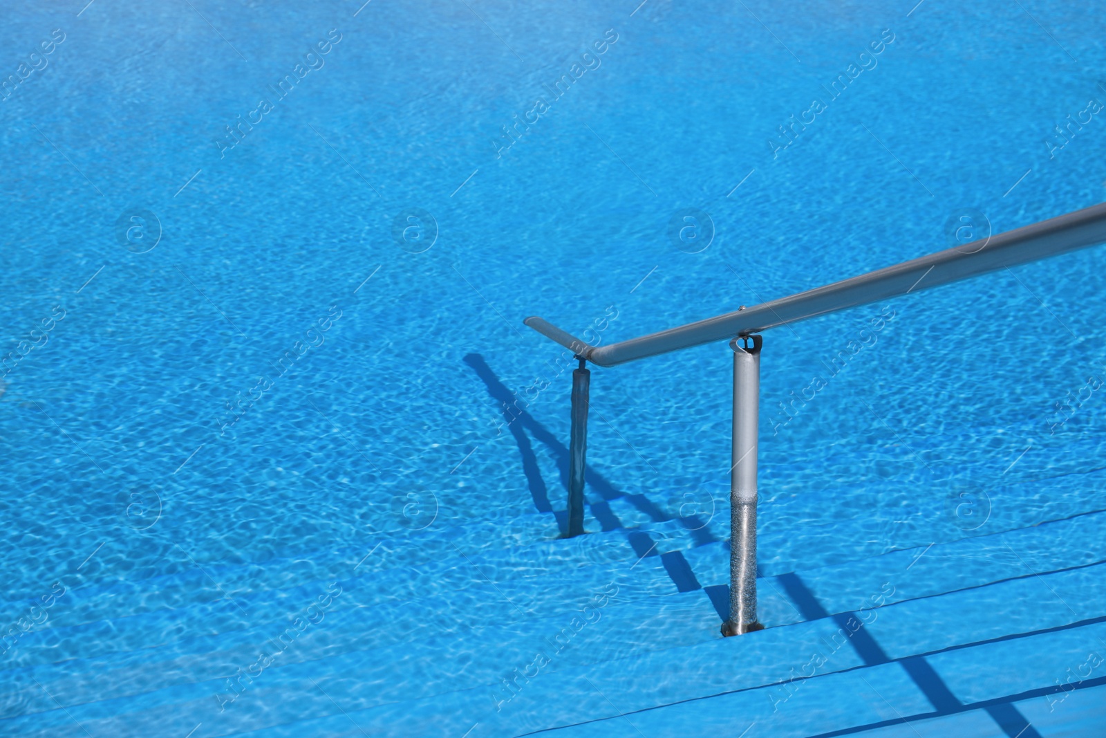 Photo of Outdoor swimming pool with clear water on sunny day. Summer vacation