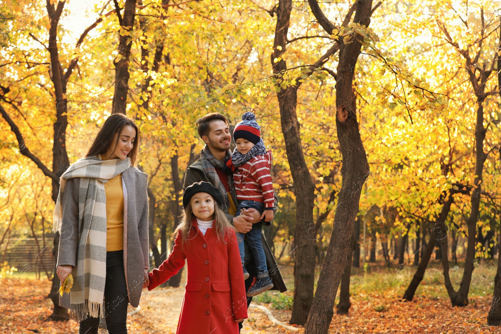 Photo of Happy family with children spending time together in park. Autumn walk