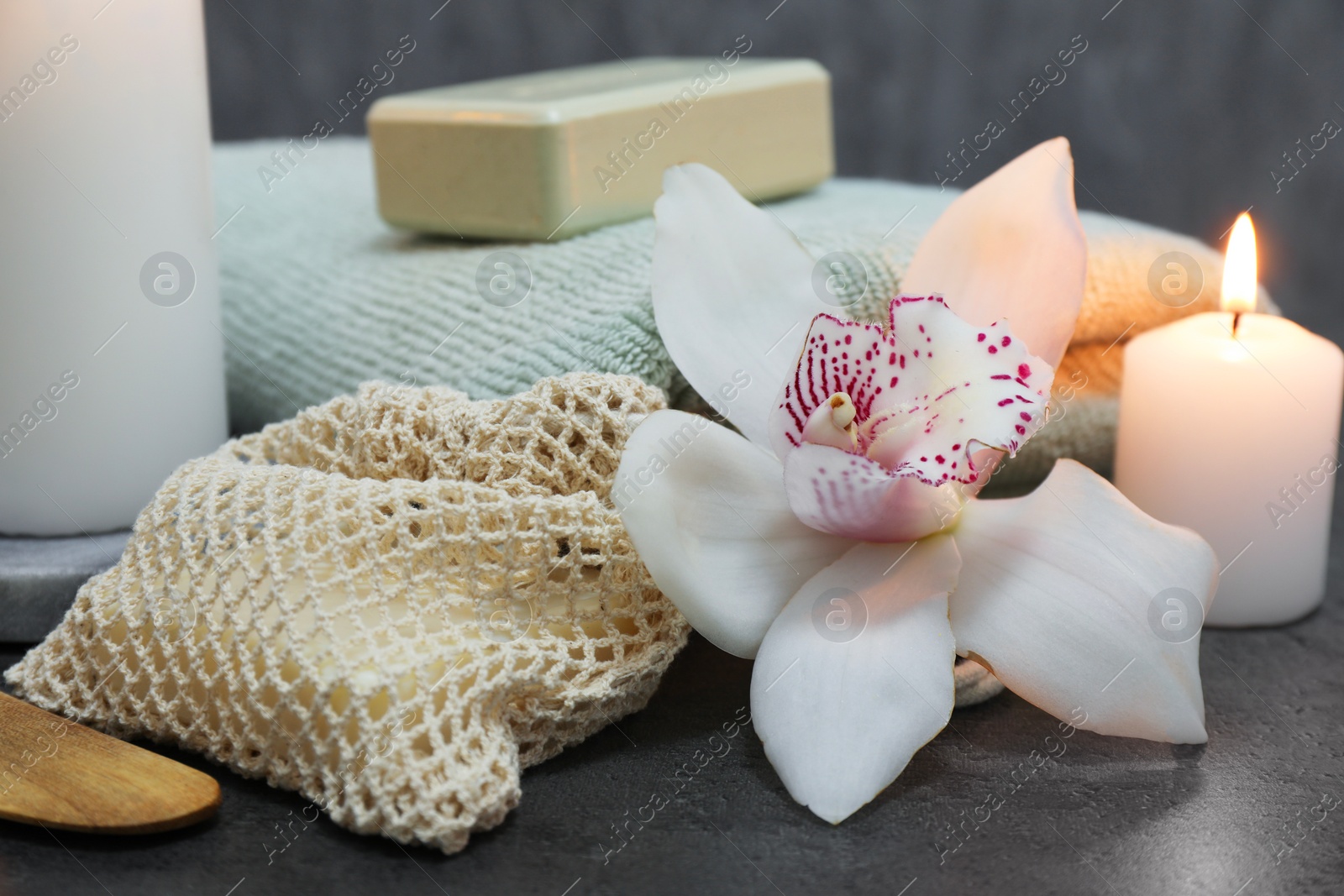 Photo of Composition with different spa products and orchid flower on grey table, closeup