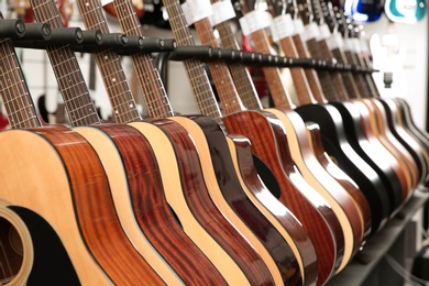 Row of different guitars in music store, closeup